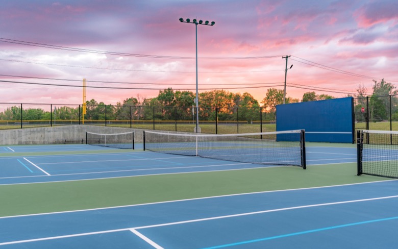 Blue and green court complex at dusk with lights on